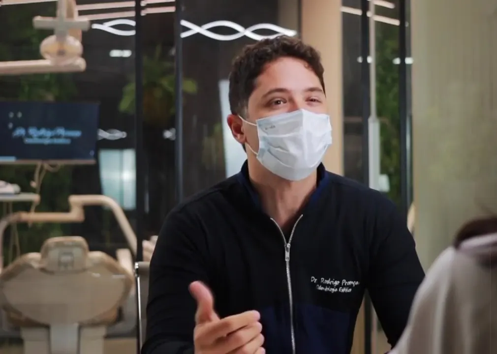 Dr. Rodrigo conversando com uma paciente no consultório